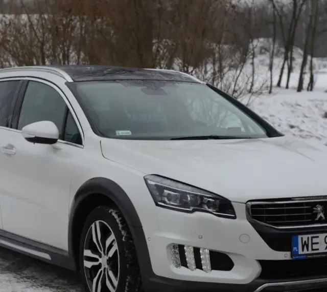Biały Peugeot 508 RXH na śniegu, gotowy na zimowe wyzwania.