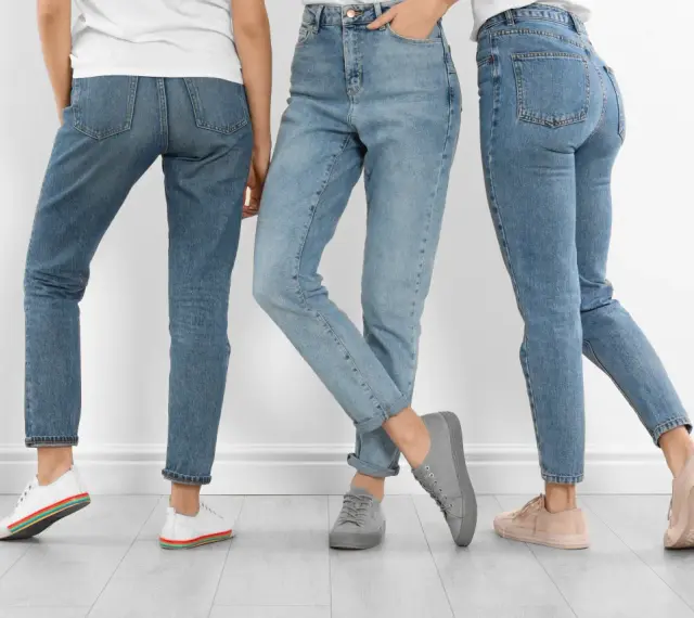 Trzy kobiety w jeansach i sneakersach. Dowiedz się, jak rozciągnąć jeansy, by były idealnie dopasowane.