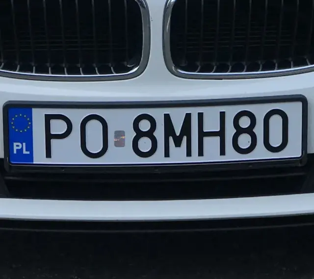 Białe BMW z tablicą rejestracyjną PO 8MH80.