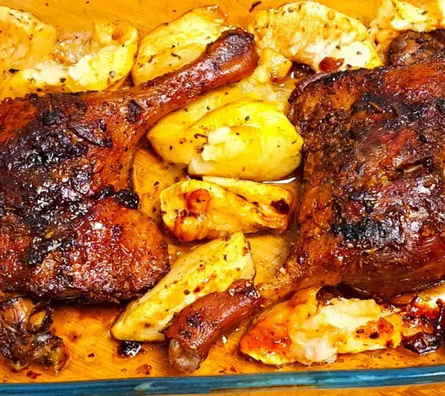 Chrupiące udka z kaczki z piekarnika, otoczone pieczonymi ziemniakami, kuszą apetycznym wyglądem i aromatem.