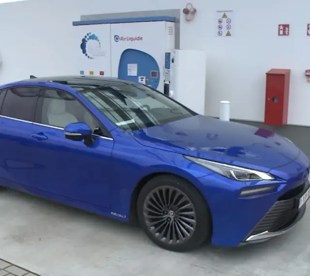 Niebieska Toyota Mirai na stacji wodorowej. Zastanawiasz się nad toyota mirai cena? To przyszłość motoryzacji.
