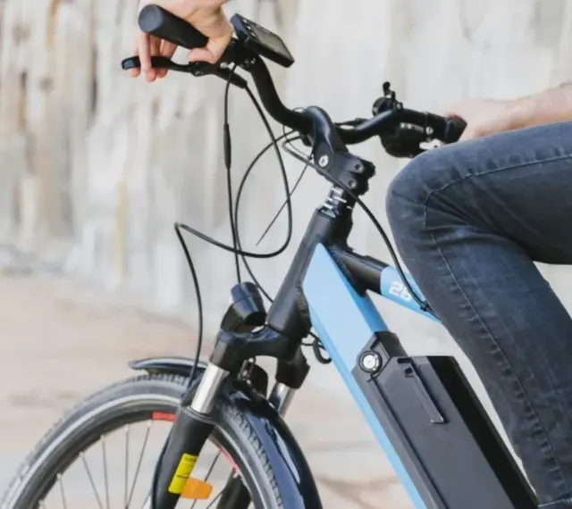 Osoba na rowerze elektrycznym, który jest pojazdem mechanicznym, jedzie po mieście.
