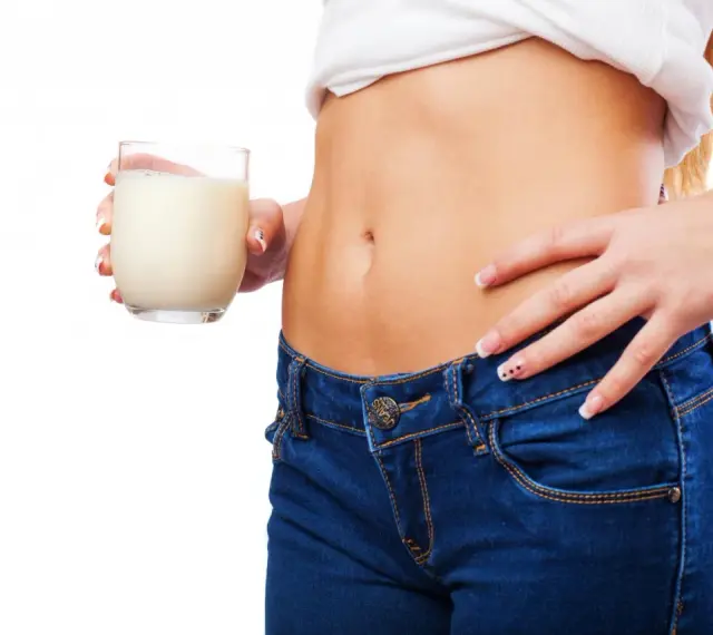 Donna con bicchiere di latte, un aiuto per sapere cosa bere la sera per andare di corpo.