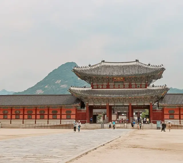 Zwiedzający pałac w Seulu, podziwiający architekturę. Czy Korea Południowa jest bezpieczna? Tak, to kraj przyjazny turystom.