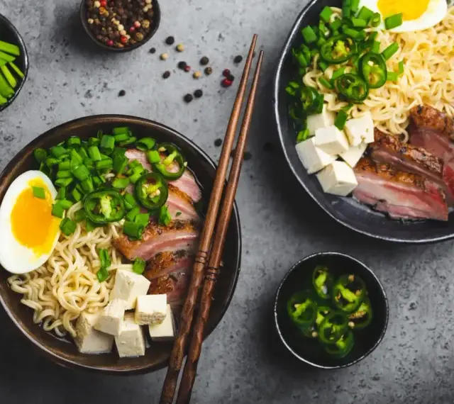 Pyszny ramen wołowy przepis: makaron, plastry mięsa, jajko, tofu, szczypiorek i papryczki jalapeño.