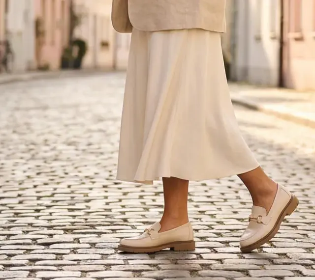 Eleganckie, beżowe mokasyny z ozdobnym złotym elementem to idealne modne buty na wiosnę.