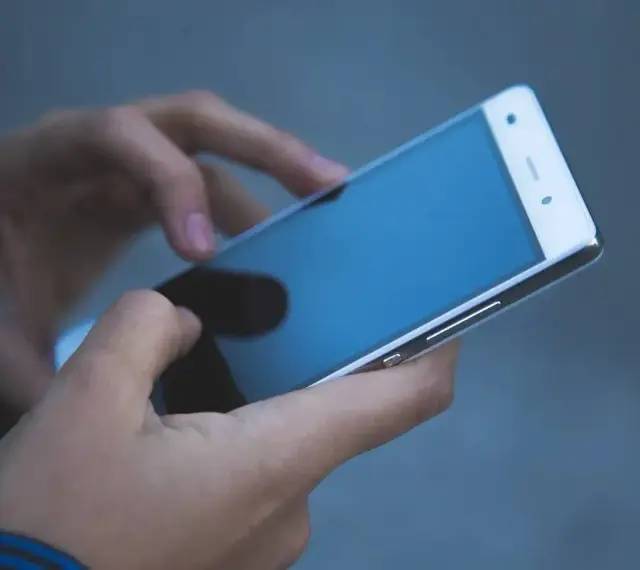 Dłonie trzymają smartfon, który może posłużyć jako telefon jako dowód w sprawie.