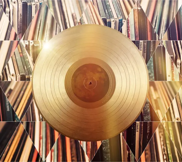 Złota płyta winylowa na tle stosów albumów. Czy to symbol tego, kto sprzedał najwięcej płyt w historii?