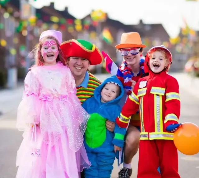 Fröhliche Familie in Kostümen feiert Fasching. Wann sind Faschingsferien in Baden-Württemberg 2026?