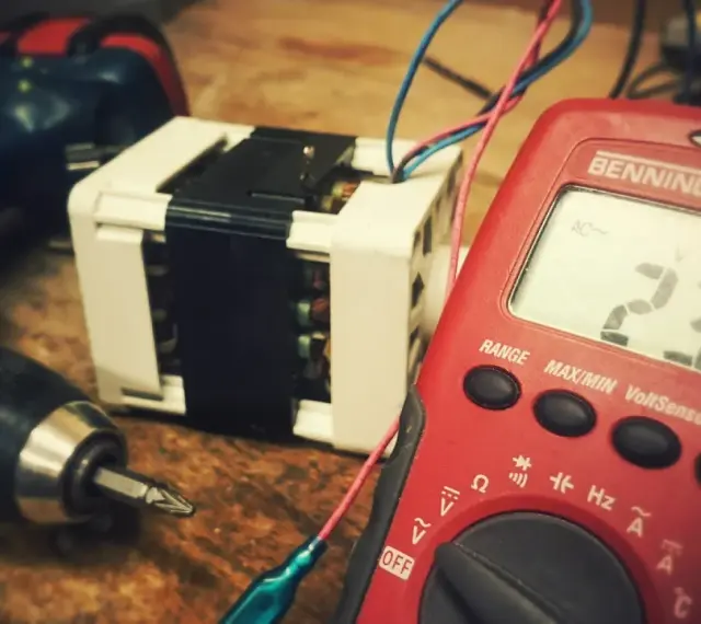Narzędzia i transformator, potencjalne odpady elektroniczne, czekają na diagnozę multimetrem.