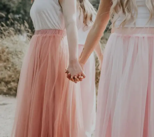 Dziewczyny w tiulowych, pudrowych sukienkach trzymają się za ręce. Ich styl to kwintesencja "soft girl".