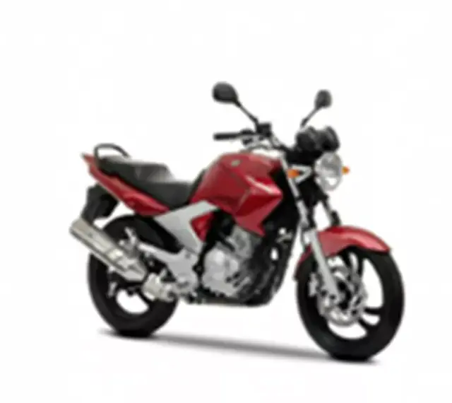 Czerwony motocykl Yamaha YBR 250 z czarnym siedzeniem i srebrnym wydechem, gotowy do jazdy po mieście.