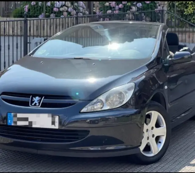 Svart Peugeot 307 CC cabriolet, taket nere. Solen reflekteras i lacken, kanske ett tecken på ett kommande problem?