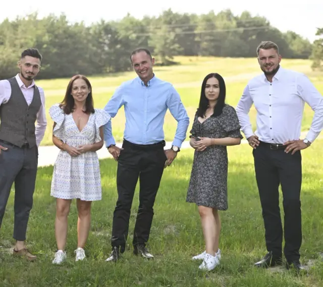 Uczestnicy programu "Rolnik szuka żony 10" pozują na tle zielonej łąki.
