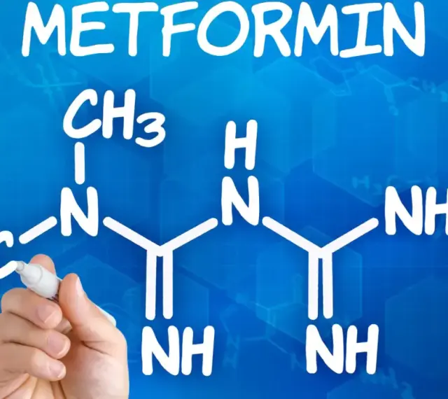 Struktura metforminy i jej potencjalne metformina skutki uboczne. Ręka pisze wzór chemiczny na niebieskim tle.