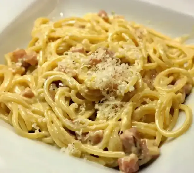 Pyszne spaghetti carbonara z kawałkami guanciale i startym parmezanem. Idealny ser do carbonary to klucz do sukcesu.