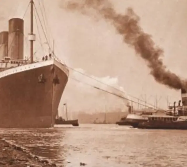 Ogromny statek, prawdopodobnie **Titanic**, wypływa z portu, holowany przez mniejsze jednostki. Dym unosi się z kominów.