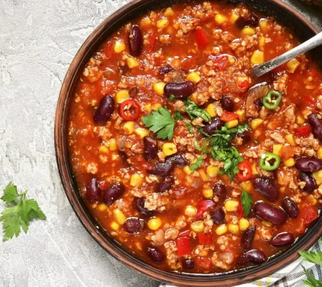 Pyszna zupa meksykańska, którą przygotowała Ania. Danie pełne fasoli, kukurydzy i mięsa mielonego, ozdobione świeżą natką pietruszki i papryczkami chili.