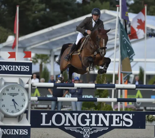 Le cavalier Cooper van de Heffinck et son cheval sautent un obstacle lors d'une compétition équestre.