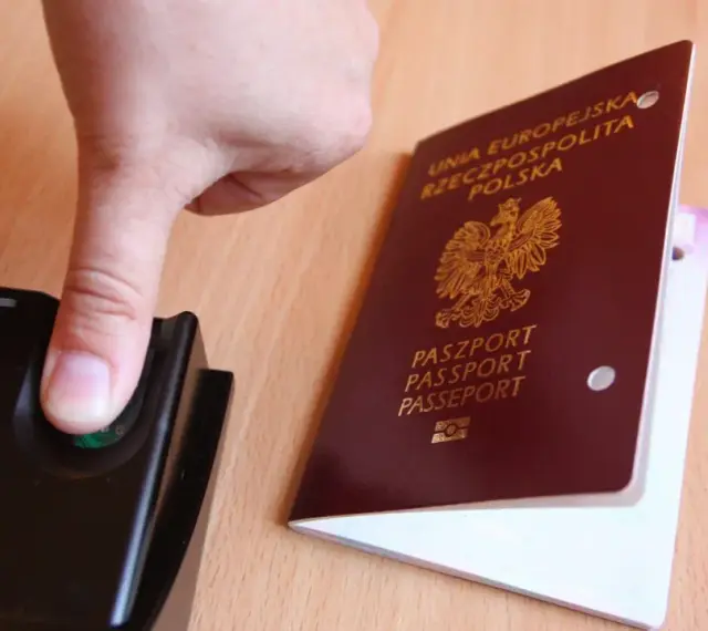 Palec na czytniku linii papilarnych obok polskiego paszportu. To pokazuje, ile ważny jest paszport w dzisiejszych czasach.