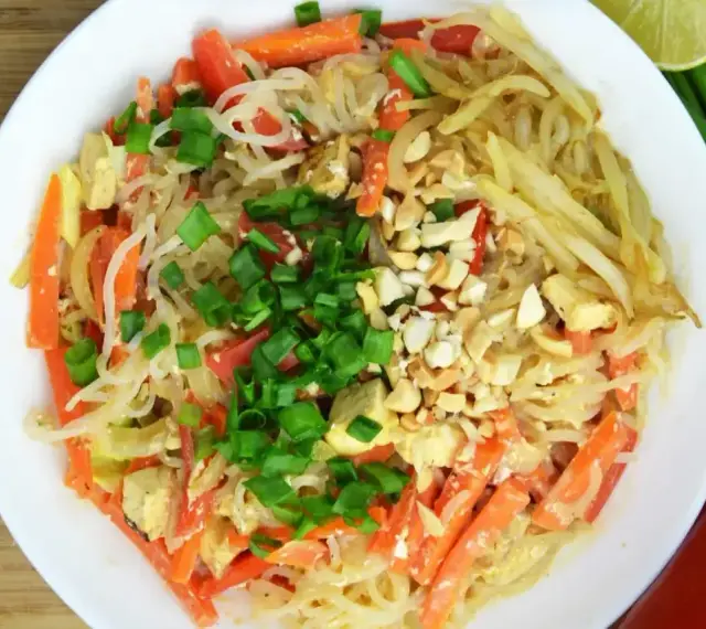 Talerz pełen pad thai z marchewką, tofu i orzeszkami ziemnymi. Zastanawiasz się nad pad thai kcal?