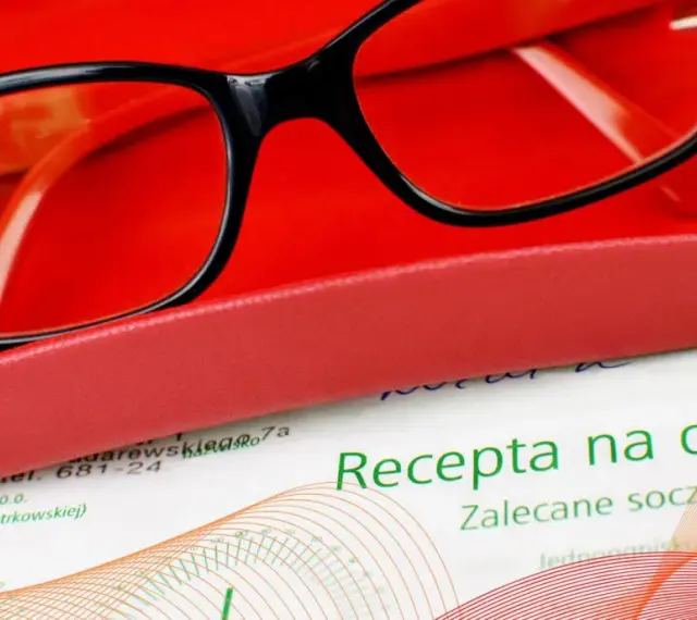 Okulary w etui na tle recepty. Ważność recepty na okulary jest kluczowa dla zakupu odpowiednich soczewek.