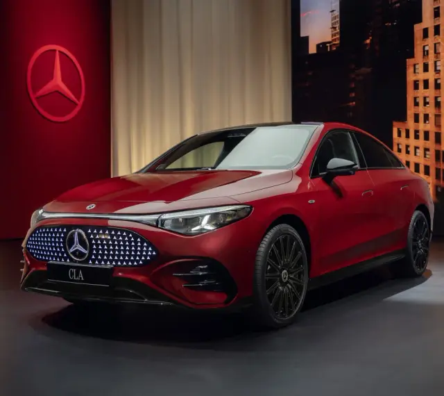 Czerwony Mercedes CLA 2025 z podświetlanym grillem i logo gwiazdy. Elegancki design, gotowy na podbój dróg.
