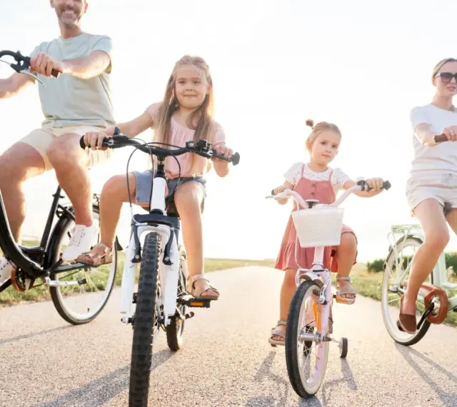 Rodzina na rowerach. Czy karta rowerowa jest obowiązkowa? Dzieci i rodzice cieszą się wspólną przejażdżką.