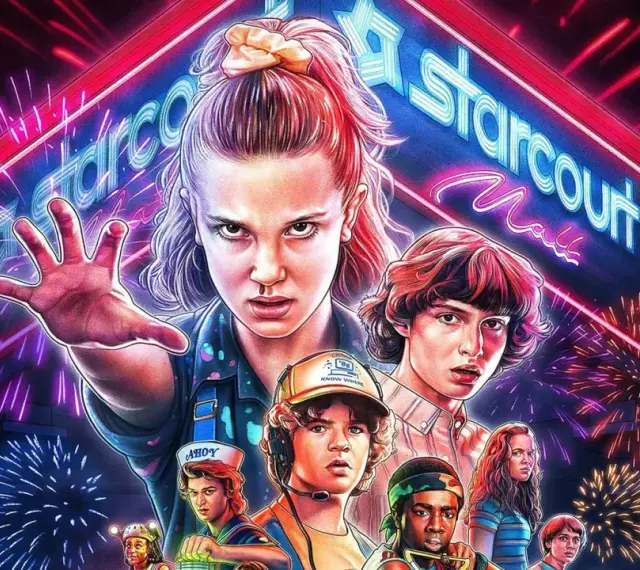 Eleven i jej przyjaciele z Stranger Things 3 gotowi do walki pod neonowym szyldem Starcourt Mall, otoczeni fajerwerkami.