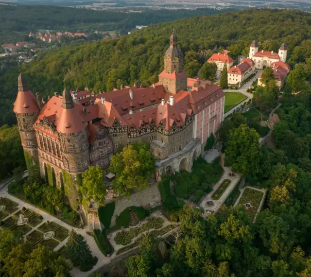 Zamek Książ z lotu ptaka, otoczony lasem. Warto zaplanować cały dzień, by w pełni docenić jego piękno.
