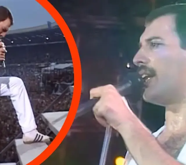 Freddie Mercury w białym stroju, z mikrofonem w dłoni, na tle tłumu. To mógł być jego ostatni koncert.