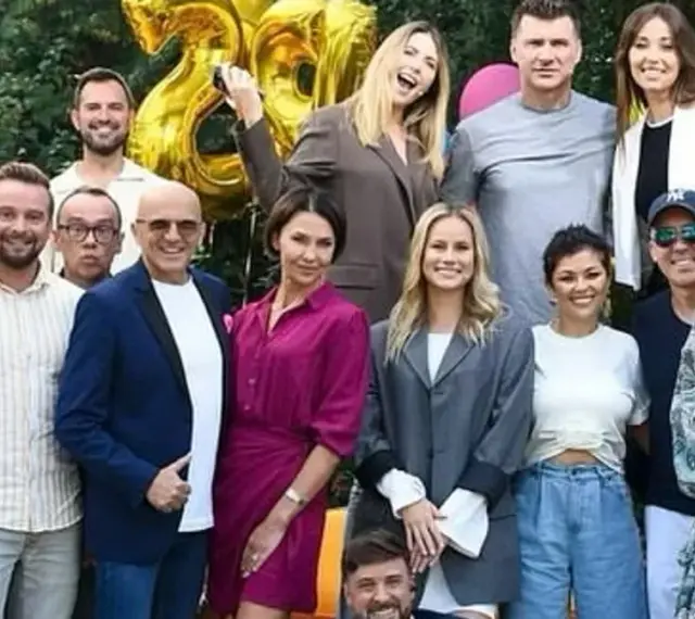 Ekipa TVP2 Pytanie na śniadanie dzisiejszy odcinek świętuje 28 lat! Radosna grupa prezenterów i gości pozuje do wspólnego zdjęcia na tle złotych balonów.
