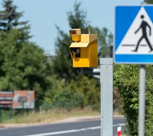 Żółty fotoradar i znak przejścia dla pieszych. Uważaj na przekroczenie prędkości o 30 w terenie zabudowanym, bo możesz dostać mandat.