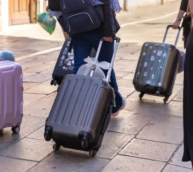 Ludzie z walizkami na kółkach, zastanawiający się, ile dopłata za bagaż Ryanair.