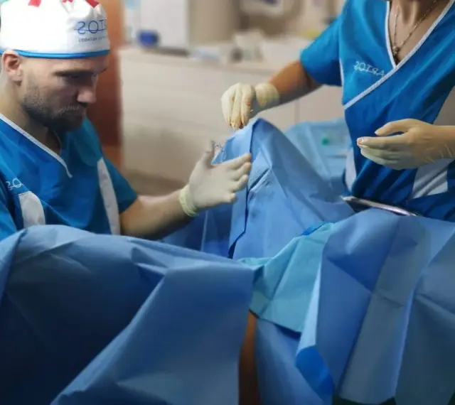 Chirurg i asystentka w rękawiczkach przygotowują się do zabiegu. Zdjęcia nieudana labioplastyka mogą pokazywać takie momenty.