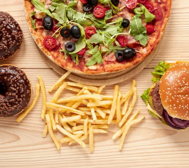 Pizza, burger, frytki i pączki z czekoladą – uczta pełna tłuszczów nasyconych.