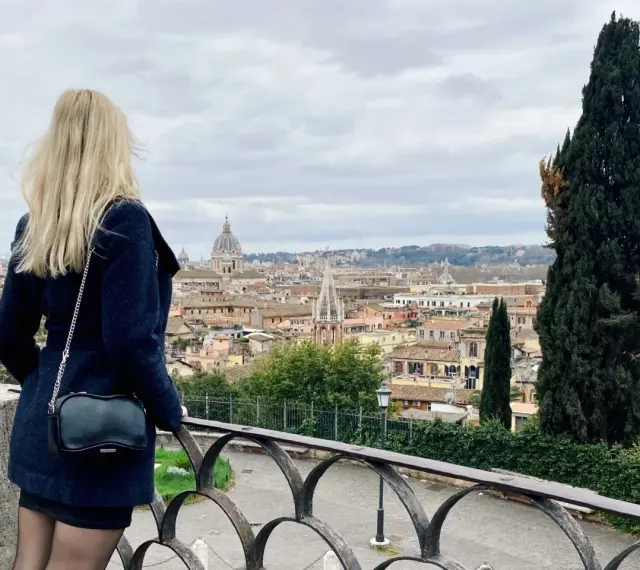 Blondynka podziwia panoramę Rzymu w listopadzie. Pochmurna pogoda nie przeszkadza w zwiedzaniu.