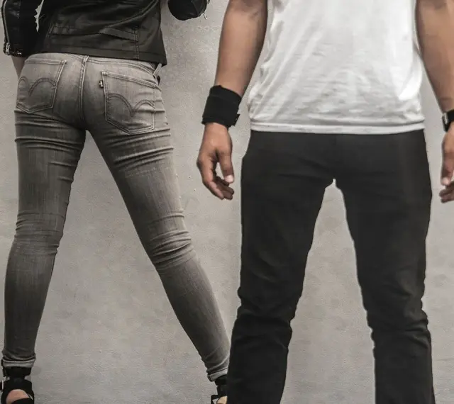 Szara, dopasowana para jeansów, widać metkę Levi's. Czy to rozmiar w25? Obok mężczyzna w czarnych spodniach.