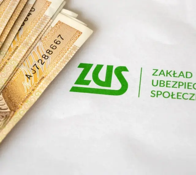 Pieniądze i logo ZUS. Symbolizuje to świadczenie rehabilitacyjne, które można uzyskać dzięki ubezpieczeniu społecznemu.
