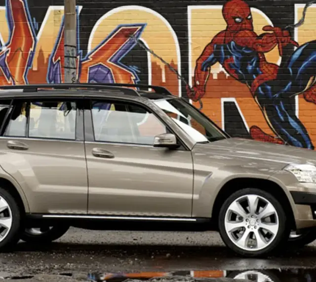 Brązowy suv Mercedes GLK na tle kolorowego graffiti z Spider-Manem.