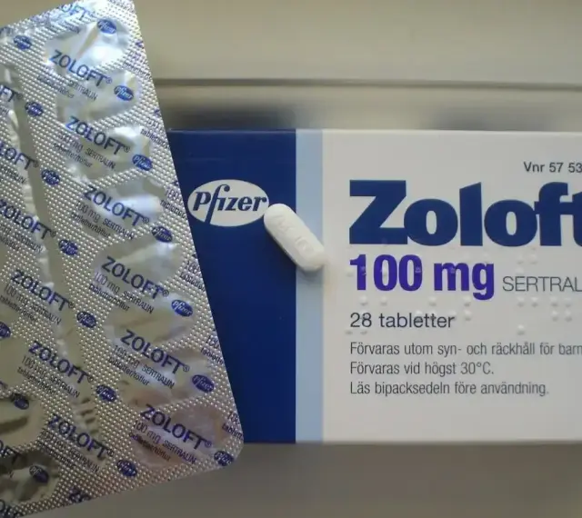 Opakowanie leku Zoloft 100 mg z sertraliną i pojedyncza tabletka. Lek ten pomaga w leczeniu depresji.