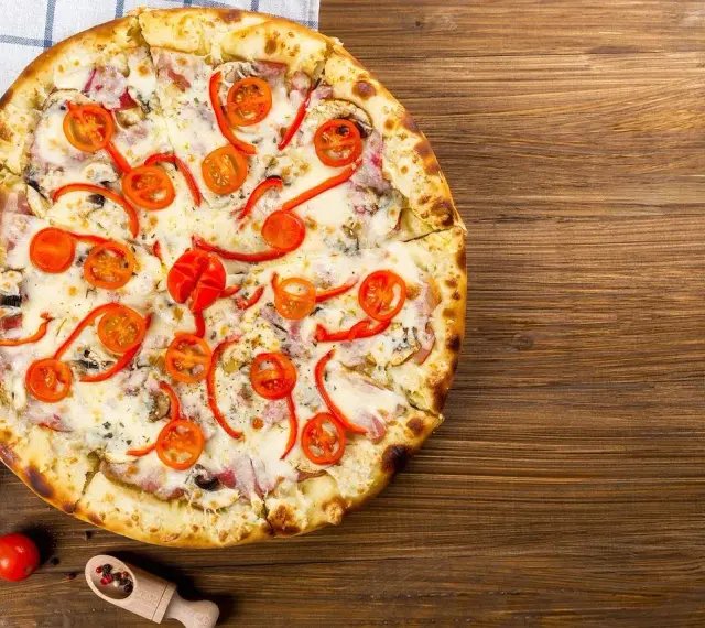 Apetyczna pizza z pomidorkami i papryką, idealna na wieczór. Czy zastanawiałeś się nad pizza hut kalorie?
