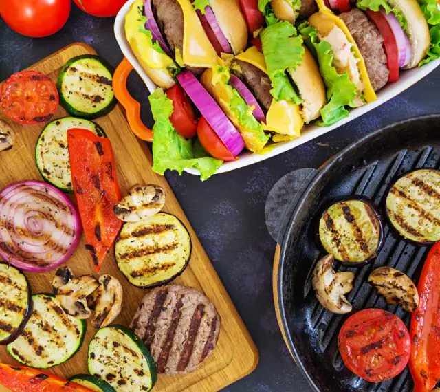 Pyszne przekąski na grilla: burgery, grillowane warzywa (cukinia, bakłażan, papryka, cebula, pomidory) i pieczarki. Idealne na letnie spotkania.