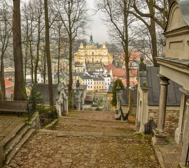 Kamienne schody prowadzą do barokowej bazyliki na wambierzyckiej kalwarii. W oddali widać miasteczko.