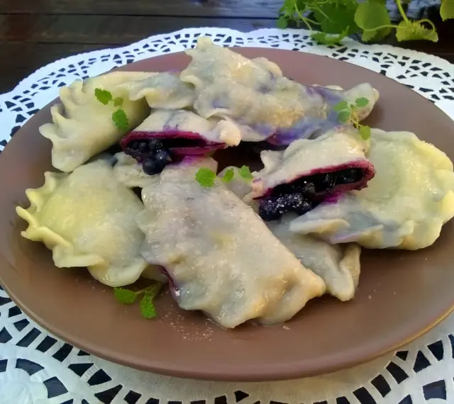 Pyszne pierogi z jagodami, delikatne i pełne owocowego smaku. Idealne na deser lub śniadanie.