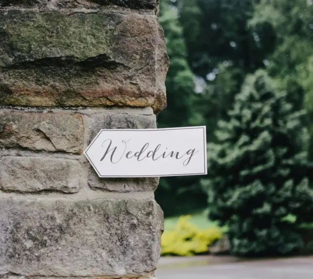 Strzałka z napisem "Wedding" wskazuje drogę do uroczystości, zapowiadając tradycyjny marsz weselny.
