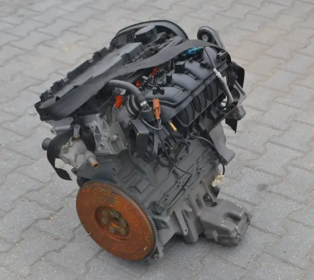 Silnik Alfa Romeo 156, gotowy do montażu. Widoczny koło zamachowe i elementy układu dolotowego.