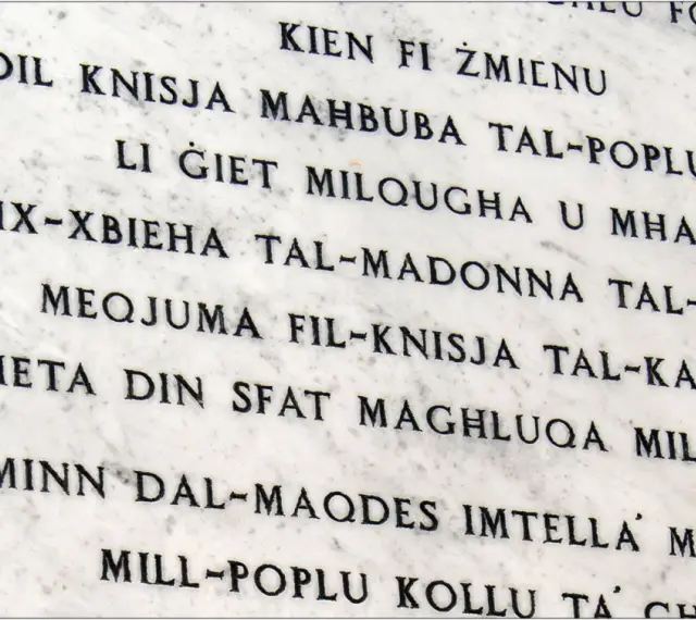 Napis na marmurze w języku maltańskim. Tekst opowiada historię o kościele i jego znaczeniu dla ludzi.