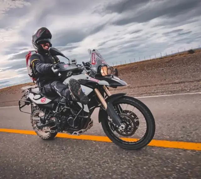 Motocyklista na BMW GS 800, mimo potencjalnych wad, cieszy się jazdą po pustej drodze.