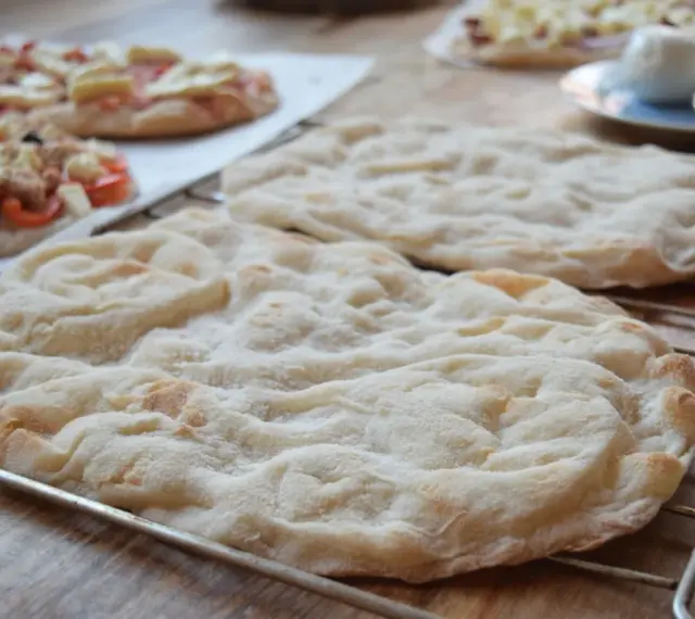 Pyszna, lekko przypieczona pinsa z czymś pysznym na wierzchu, gotowa do podania.